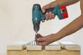 Hand of a worker screws a in a wooden board with a cordles Royalty Free Stock Photo