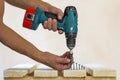 Hand of a worker screws a in a wooden board with a cordles Royalty Free Stock Photo