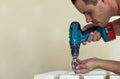 Hand of a worker screws a in a wooden board with a cordles Royalty Free Stock Photo