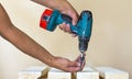 Hand of a worker screws a in a wooden board with a cordles Royalty Free Stock Photo