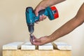 Hand of a worker screws a in a wooden board with a cordles Royalty Free Stock Photo