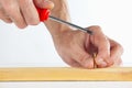 The hand of the worker tightening the in a wooden block