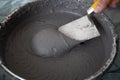 Hand with a Trowel in a Bucket with Plaster