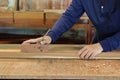 Hand of worker working with a hand planer on a plank of wood. Royalty Free Stock Photo