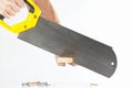 Hand of a workman cutting a wooden block with a handsaw Royalty Free Stock Photo