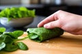 hand wrapping a burrito with a spinach flour tortilla