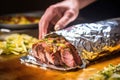 hand wrapping foil around takeaway beef taco