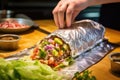hand wrapping a fresh chalupa in foil Royalty Free Stock Photo