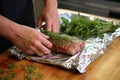 hand wrapping herb-marinated ribs in foil