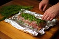 hand wrapping herb-marinated ribs in foil