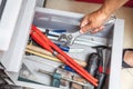 Hand wrench takes out metal box with different tool Royalty Free Stock Photo