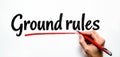 Hand writes Ground rules with red pen on white paper. Establishing guidelines, setting expectations, clarifying terms. Business Royalty Free Stock Photo