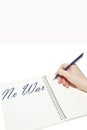 Hand writes the inscription `No war` with a pen in a notebook Royalty Free Stock Photo