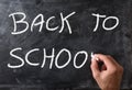 Hand writing back to school on blackboard with chalk Royalty Free Stock Photo