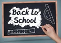 Hand writing back to school on blackboard with chalk and rulers Royalty Free Stock Photo