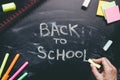 Hand writing back to school. School supplies on the chalkboard background, education concept Royalty Free Stock Photo