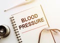 Hand writing blood pressure withstethoskope and themometre, health concept background Royalty Free Stock Photo