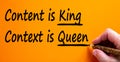 Hand writing `content is king, context is queen`, isolated on beautiful orange background. Business concept, copy space Royalty Free Stock Photo