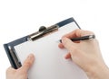 Hand writing on an empty document in a clipboard Royalty Free Stock Photo