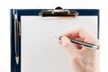 Hand writing on an empty document in a clipboard Royalty Free Stock Photo