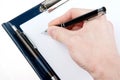 Hand writing on an empty document in a clipboard Royalty Free Stock Photo