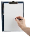 Hand writing on an empty document in a clipboard Royalty Free Stock Photo