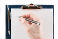Hand writing on an empty document in a clipboard Royalty Free Stock Photo