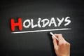 Hand writing Holidays on blackboard, holiday concept background Royalty Free Stock Photo