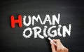 Hand writing Human origin on blackboard, concept background