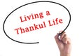 Hand writing Living a Thankful Life on transparent board