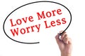 Hand writing Love More Worry Less on transparent board