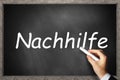 Hand writing Nachhilfe engl. tutoring on black wooden chalkboard Royalty Free Stock Photo