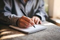 Hand writing on notebook, soft lighting from window creating inviting, creative vibe