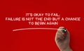 Hand writing It is okay to fail affirmation on red cover background. Affirmation concept.