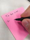 Hand writing with pen on a sheet of paper post-it to do list Royalty Free Stock Photo