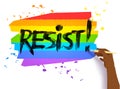 Hand writing Resist slogan on lgbt flag