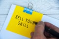 Hand writing sell your skill text on yellow notepad. Skill concept Royalty Free Stock Photo