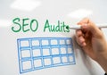 Hand writing seo audits and drawing a grid on a whiteboard Royalty Free Stock Photo