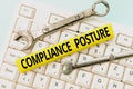 Hand writing sign Compliance Posture. Business showcase manage the defense of the enterprise and assure resources Typing