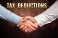 Hand writing sign Tax Deductions. Word for reduction income that is able to be taxed of expenses Two Professional Well