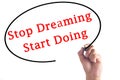 Hand writing Stop Dreaming Start Doing on transparent board