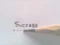 Hand writing success wording on paper with pencil Royalty Free Stock Photo