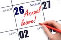 Hand writing the text ANNUAL LEAVE and drawing the sun on the calendar date March 26