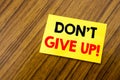 Hand writing text caption inspiration showing Don t Give Up. Business concept for Motivation Determination, written on sticky note