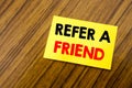 Hand writing text caption inspiration showing Refer A Friend. Business concept for Referral Marketing written on sticky note paper