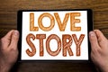 Hand writing text caption Love Story. Business concept for Loving Someone Heart Written on tablet laptop, wooden background with