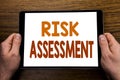 Hand writing text caption Risk Assessment. Business concept for Safety Danger Analyze Written on tablet laptop, wooden background Royalty Free Stock Photo