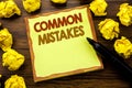 Hand writing text caption showing Common Mistakes. Business concept for Common Concept Written on sticky note paper, wooden backgr Royalty Free Stock Photo