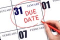 Hand writing text DUE DATE on calendar date January 31 and circling it. Payment due date Royalty Free Stock Photo