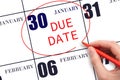 Hand writing text DUE DATE on calendar date January 30 and circling it. Payment due date Royalty Free Stock Photo